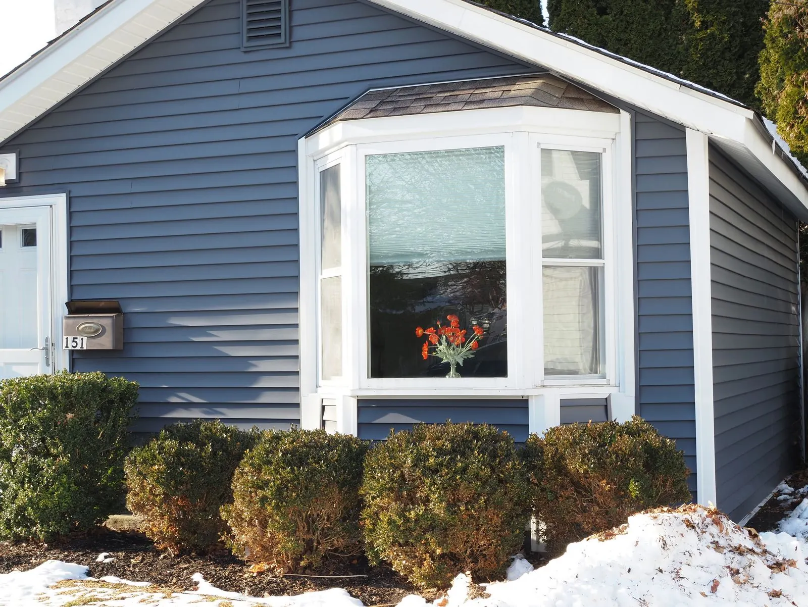 Blue sided home with a large bay window